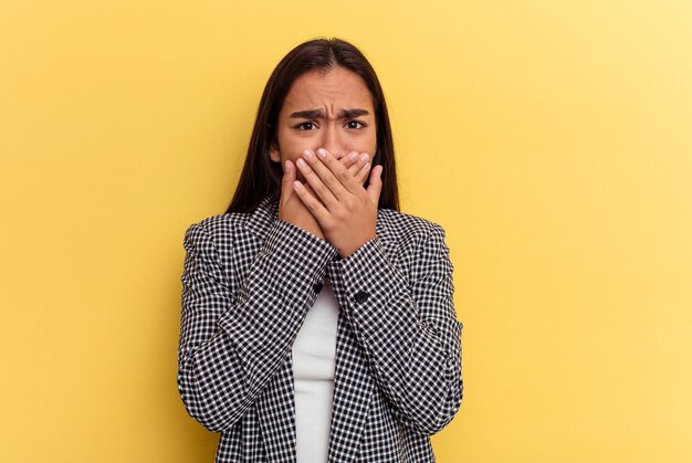 Young woman covering mouth with hands looking worried.