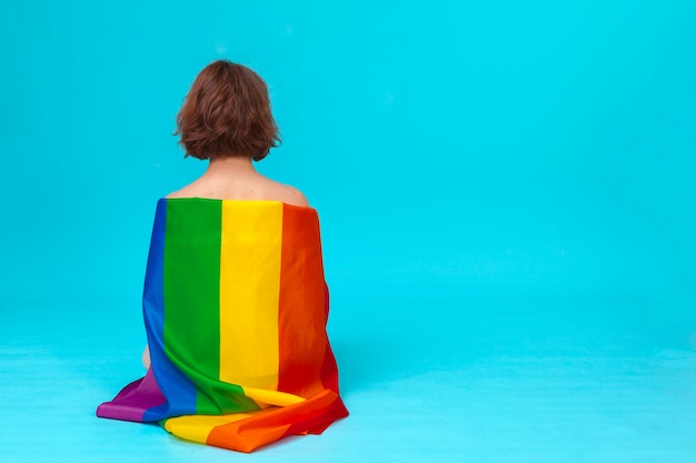 Молодая женщина покрывает с гордостью флаг ЛГБТ