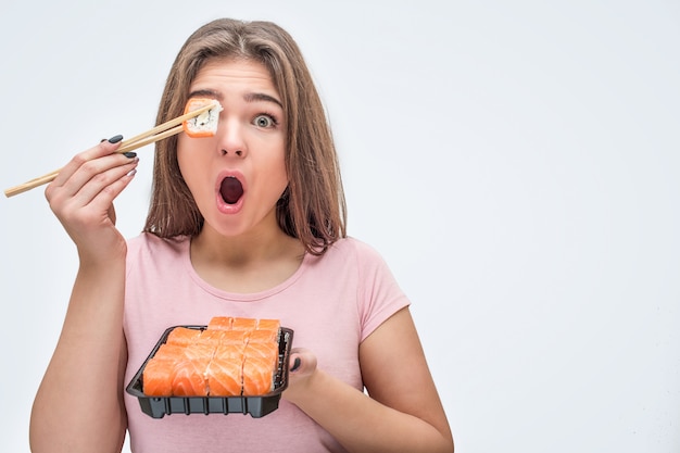 Young woman covers one eye with piece of roll