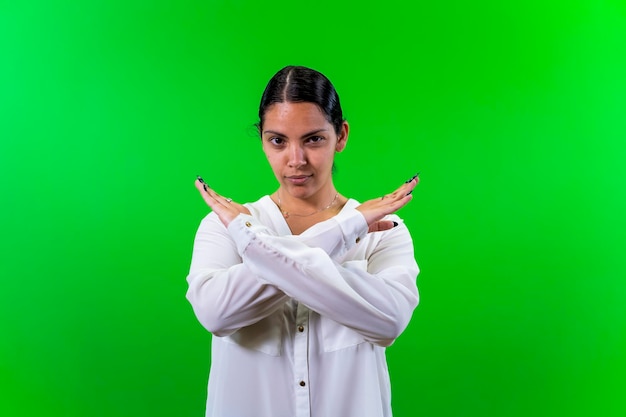 Young woman crossing her arms green background