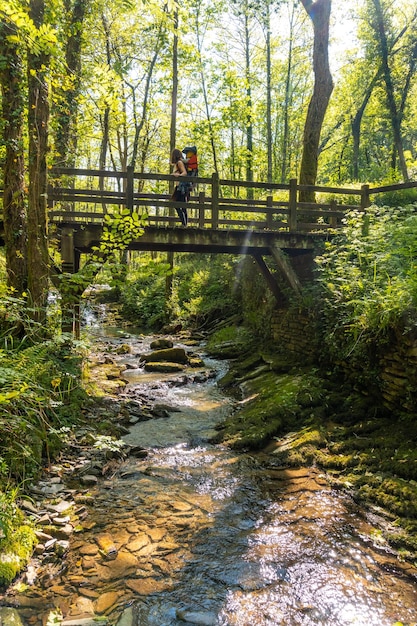 Una giovane donna che attraversa un ponte di legno nel parco della pagoeta nei paesi baschi di aia guipuzcoa