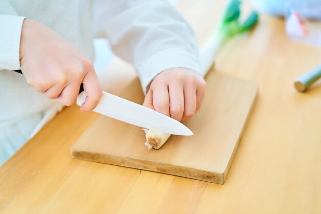 ナイフで食材を切る若い女性