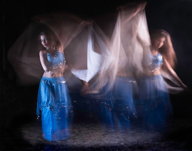 young woman dancing against black background