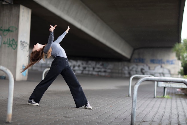 Foto giovane donna che balla sotto il ponte