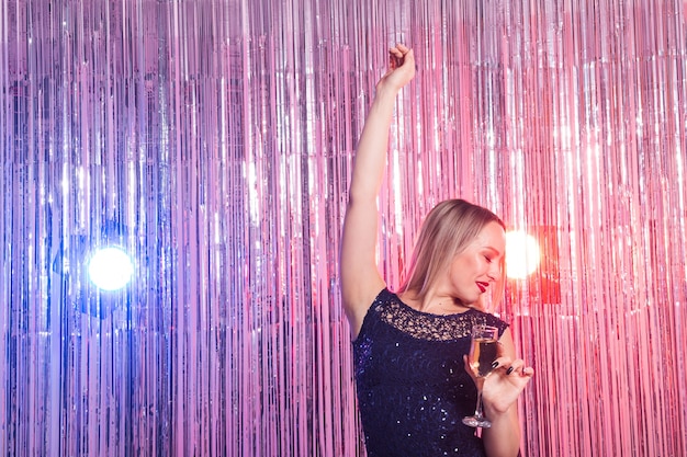 Young woman dancing at night disco club