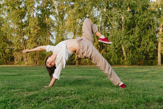 Young woman dancing outdoors on green grass