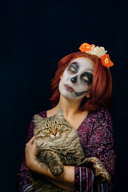 A young woman in day of the dead mask skull face art.