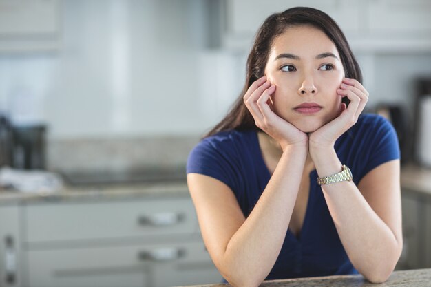 キッチンで空想にふける若い女性