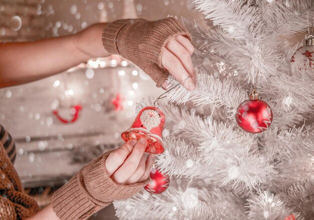 家でクリスマスツリーを飾る若い女性