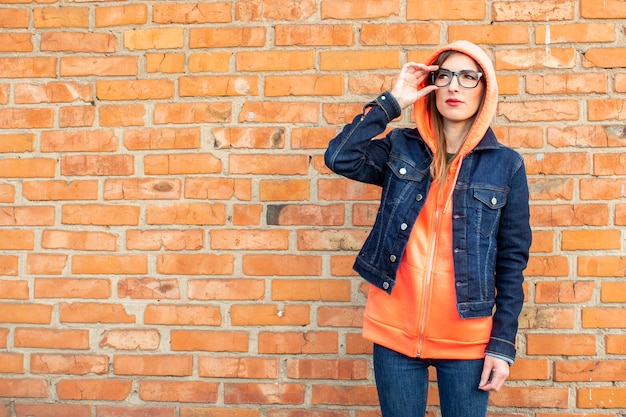 Young woman in a denim jacket and glasses