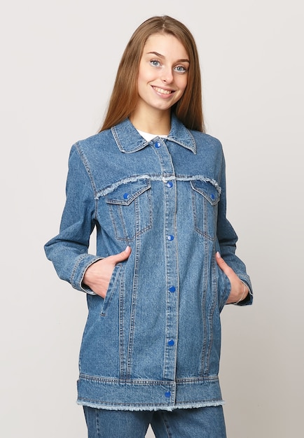 Young woman in denim suit on a white background