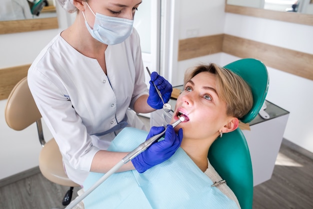 Young woman at the dentist consultation. Checking and dental treatment in a dental clinic. Oral hygiene and treatment.