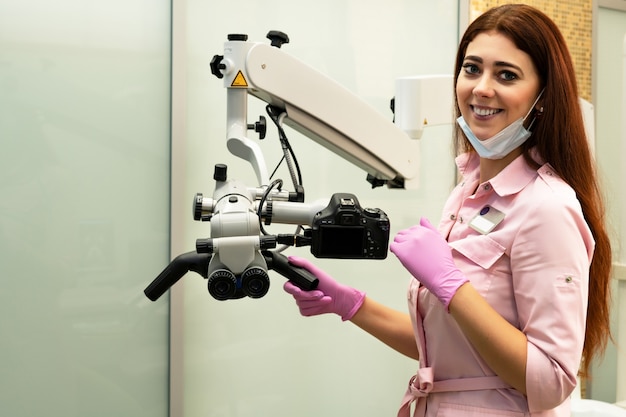 Young woman dentist and professional microscope in a dental clinic