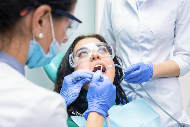 Young woman and dentists Lady in protective glasses