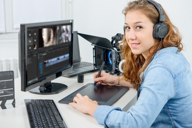Progettista di giovane donna che utilizza la tavoletta grafica per l'editing video