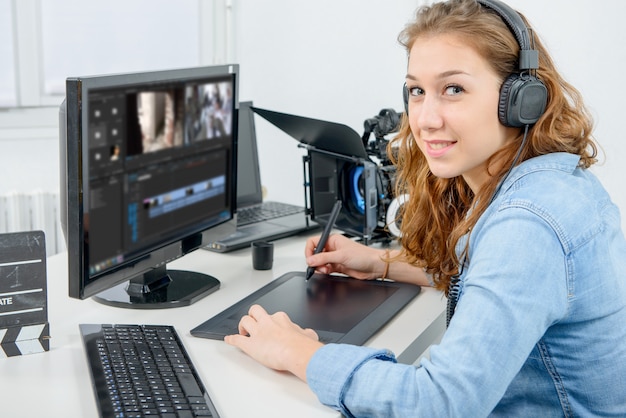 Young woman designer using graphics tablet for video editing