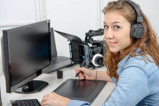 Young woman designer using graphics tablet for video editing