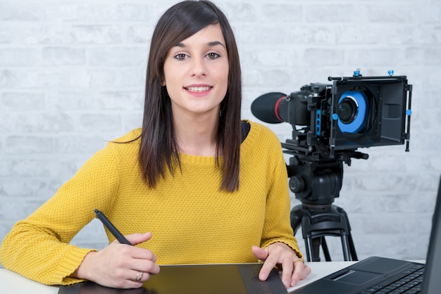 Young woman designer using graphics tablet for video editing