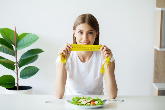 Young woman on a diet eats only salad and tries to lose weight