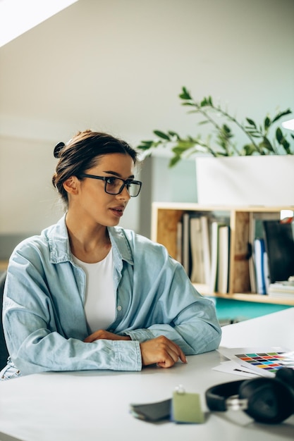 写真 タブレットとコンピューターに取り組んでいる若い女性のデジタルデザイナー