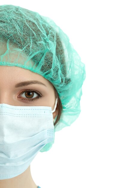 Young woman doctor in cap and face mask close-up portrait isolated. Healthcare, medical and surgery concept