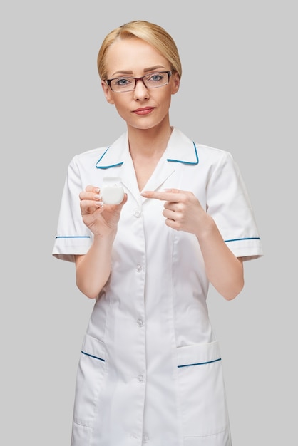 Young woman doctor holding dental floss teeth cleaning thread box for cleaning teeth - dental care and hygiene.