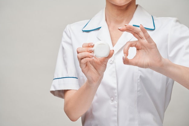 Giovane donna medico azienda filo interdentale denti pulizia scatola filettatura per la pulizia dei denti - igiene e cura dentale.