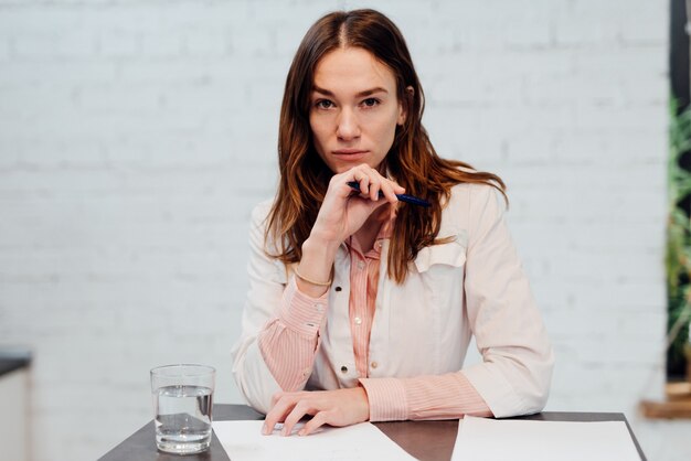 Young woman doctor sits at her desk.