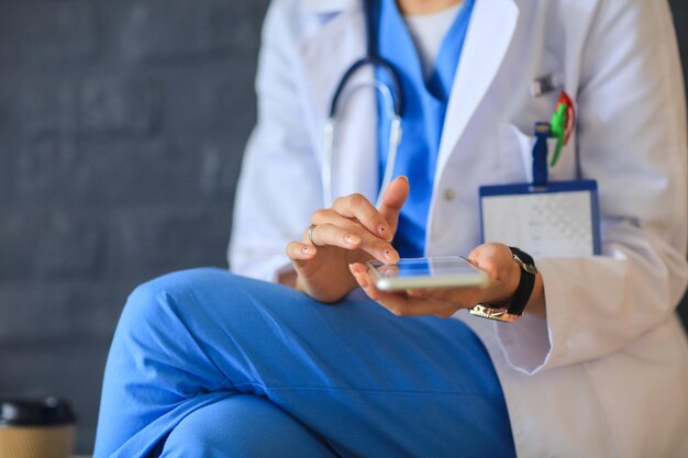 Young woman doctor sitting with your phone