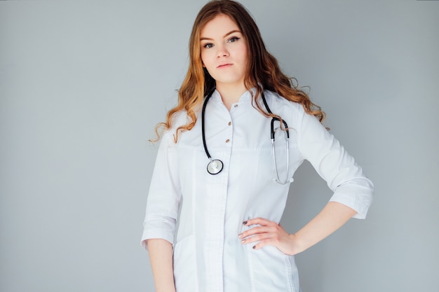 Young woman doctor in a white coat and medical mask. The medicine