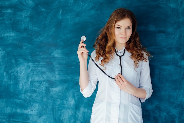 Young woman doctor in a white coat and medical mask. The medicine