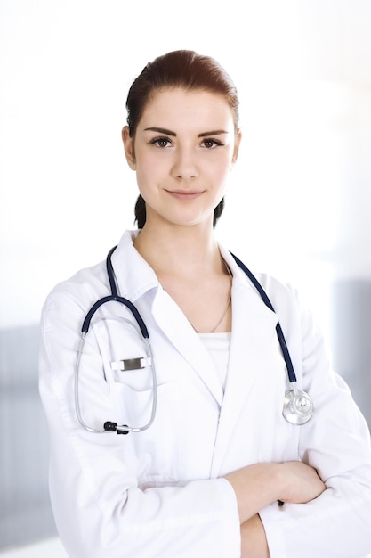 Young woman doctor at work in hospital looking at camera. Khaki colored blouse of therapist looks good. Medicine and healthcare concept.