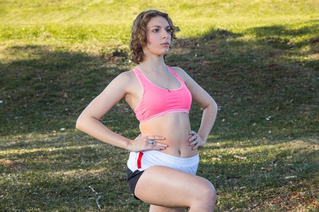 Photo a young woman does exercises in the park