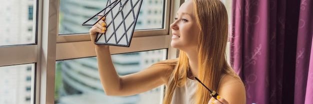 Young woman does makeup sitting by the window with a panoramic view of the skyscrapers and the big
