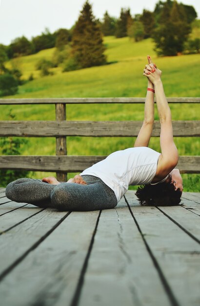 Foto giovane donna che fa asana in montagna in estate