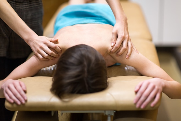 Young woman doing back massage in spa