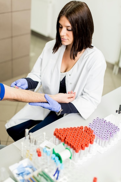 Young woman doing blood sampling in modern medical laboratory