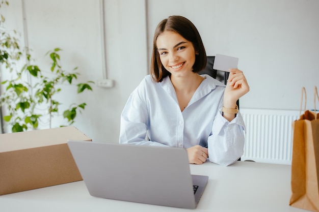 Young woman doing ecommerce shopping in front of a laptop