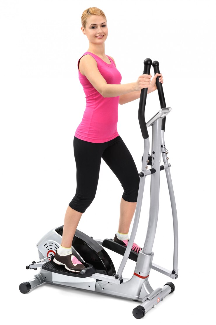 Young woman doing exercises on elliptical trainer