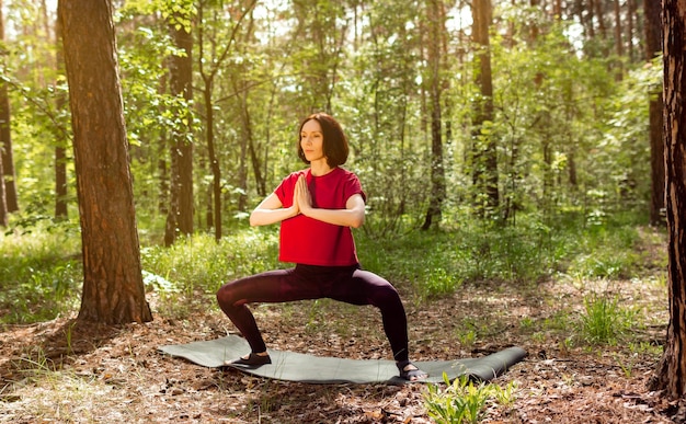 公園で屋外の朝のトレーニングの練習をしている若い女性