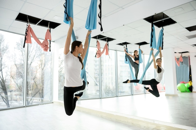 Молодая женщина делает упражнения йоги летать в тренажерном зале