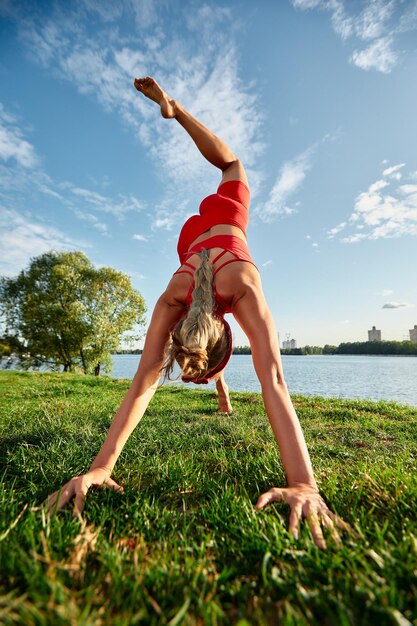 Young woman doing innovative animal flow movement outdoors training animal flow at sunset