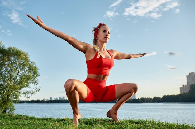 Giovane donna che fa movimento innovativo del flusso animale all'aperto addestrando il flusso animale al tramonto