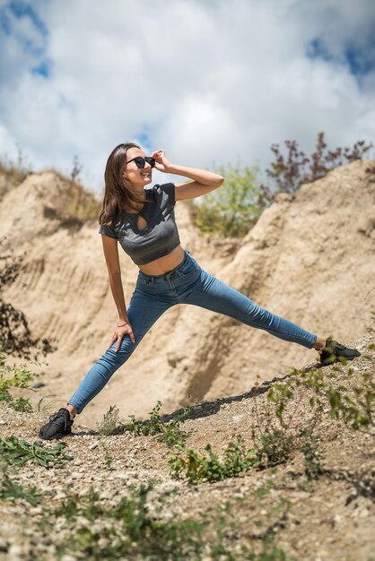 화창한 날 모래 채석장 요가 휴식에서 가벼운 운동을 하는 젊은 여성
