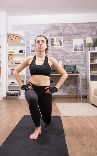 Young woman doing lunges exercise at home for a fit body.