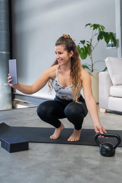 Giovane donna che fa palestra online a casa