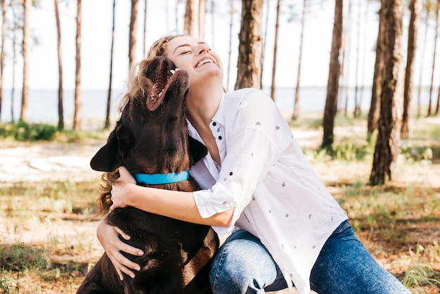 彼女の犬と一緒にピクニックをしている若い女性