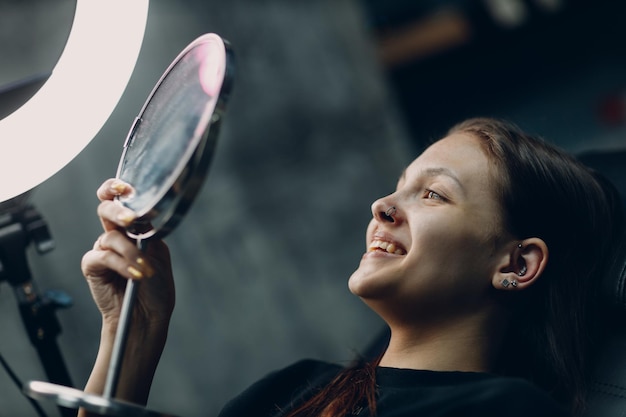 Giovane donna che fa piercing al salone di bellezza