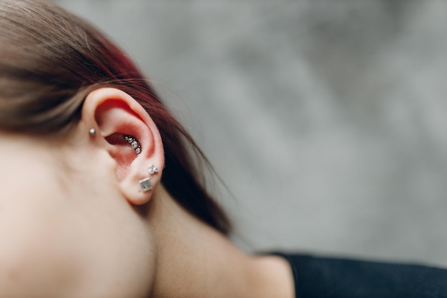 Young woman doing piercing at beauty studio salon