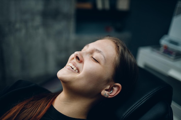 Young woman doing piercing at beauty studio salon